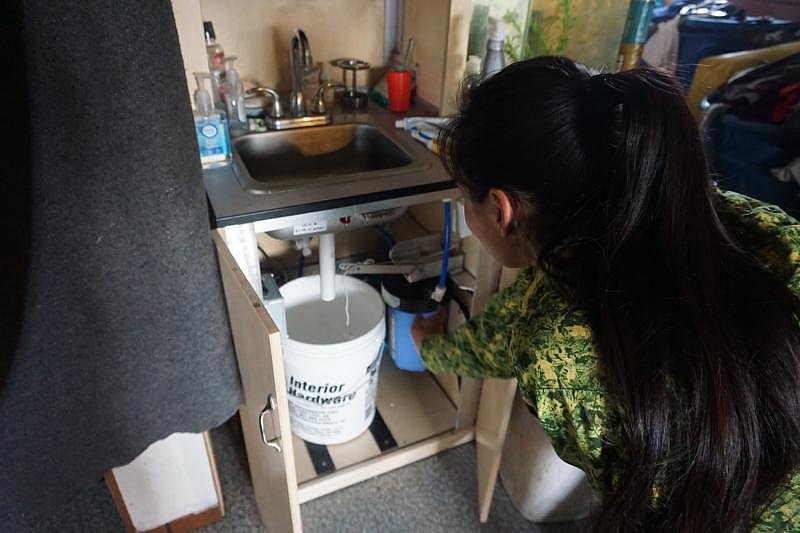 Blanche Okbaok-Garnie, the mayor of Teller, Alaska — which isn't served by water and sewer pipes — shows the Mini-PASS home sanitation system in her house. (Yereth Rosen)