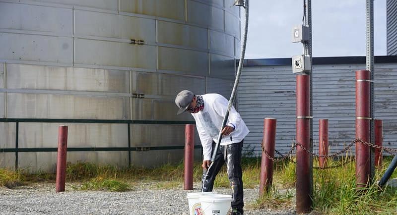 Zack Kitkon fills buckets with water from a supply provided by the city of Teller for 50 cents per gallon. Households in unserved and underserved communities in rural Alaska often make do with much less water than health experts recommend. (Yereth Rosen) Zack Kitkon fills buckets with water from a supply provided by the city of Teller for 50 cents per gallon. Households in unserved and underserved communities in rural Alaska often make do with much less water than health experts recommend. (Yereth Rosen)