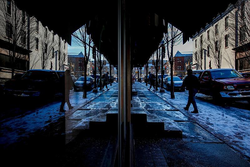 South New Street is reflected in the front window of Car Village Title and Notary. The street acts as a critical gateway into South Bethlehem's commercial core, making its future hotly debated. Residents and developers differ on what it should look like. Saed Hindash | For lehighvalleylive.com