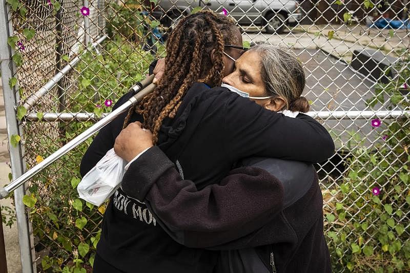 Lynn Boswell, a recovery coach with Thresholds, gets a hug from Elizabeth Elamri. Ashlee Rezin / Sun-Times