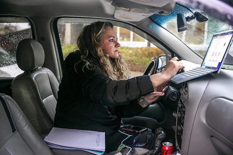 Kathryn Sharpe, preparing for a virtual meeting for work, uses the Arlington library to access Wi-Fi because of unreliable service at home, just north of the city. Sometimes, she has to keep the car running for heat. (Amanda Snyder / The Seattle Times)