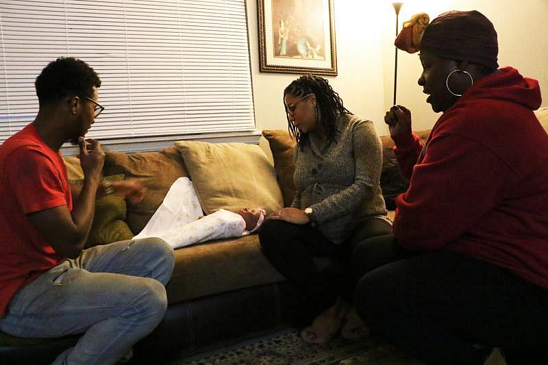 Daniel and Carmen Gibson practice swaddling a baby doll with help from their doula, Ashlee Wilson (right). KASSIE McCLUNG/The Frontier