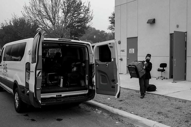 Nereida Aguirre, an employee of San Antonio Vascular and Endovascular Clinic, helps load a van headed to its Floresville location. (Josie Norris)