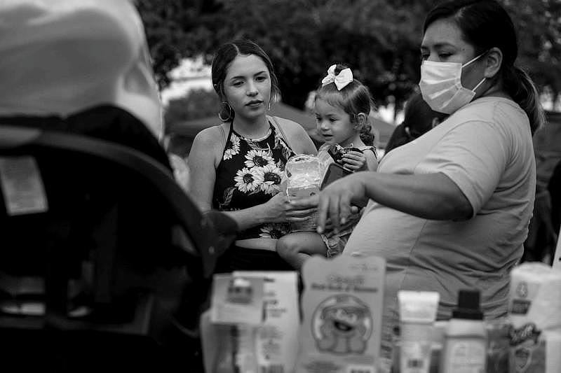 Esmeralda Salinas holds her 2-year-old daughter, Elina Arredondo, as she gets information about health care resources at a community baby shower held in October at Texas Vista Medical Center. (Josie Norris)