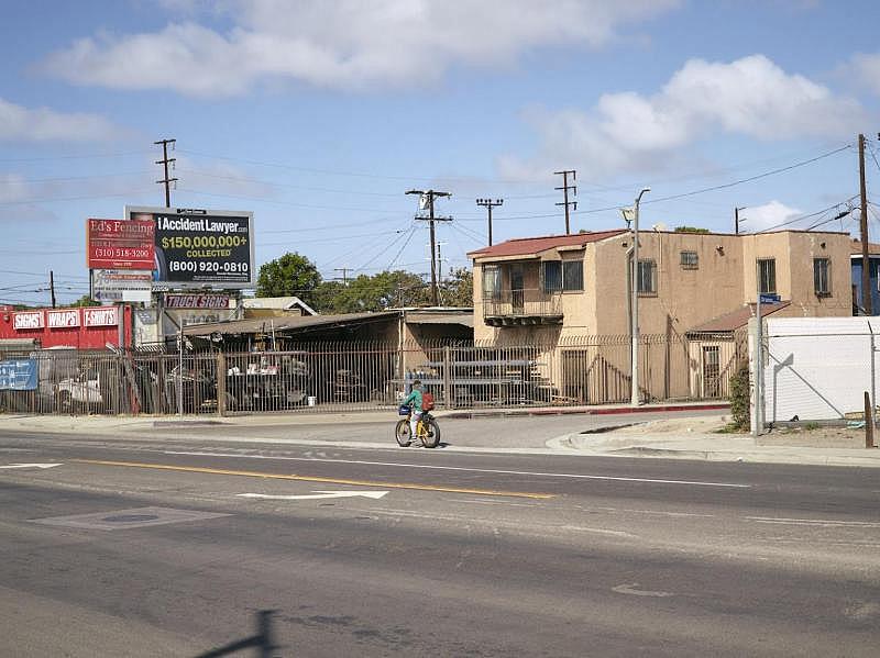 A bicyclist rides past Drumm St and Pacific Coast Highway, where 19-year-old Daniel Felipe Delgado was killed by gunfire on July 5, 2020. Damon Casarez / The Guardian