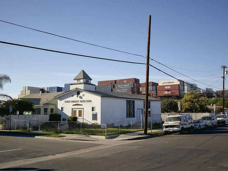 Shipping containers are stacked in a yard next to The Canaan Community Prayer Chapel. Damon Casarez / The Guardian