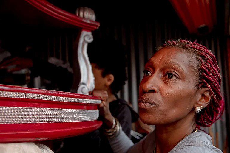 Tanya Austin moves an altar table, one of her most precious furniture, to take out clothes she and her son need. She used to decorate her previous house with the table, elephants, candles and angel statues with a Burgundy color theme, Austin said. YEHYUN KIM / CTMIRROR.ORG