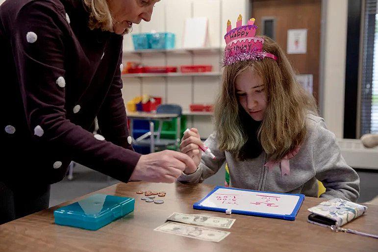 Loryann Pisani takes a math class from teacher Noreen Branley, where she learns how to purchase items effectively. Despite Loryann's concern before moving to a new place, she said she's doing well at her new school. YEHYUN KIM / CTMIRROR.ORG