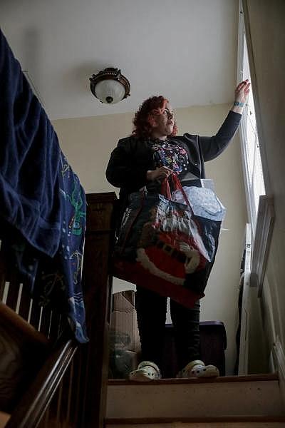 Carmen Diaz gets ready to leave for work after cleaning her sons' rooms. Carmen and her sons moved out and back into the house after her landlord filed an eviction against her. She worries about the long-term effects of repeated moves on her sons. YEHYUN KIM / CT MIRROR