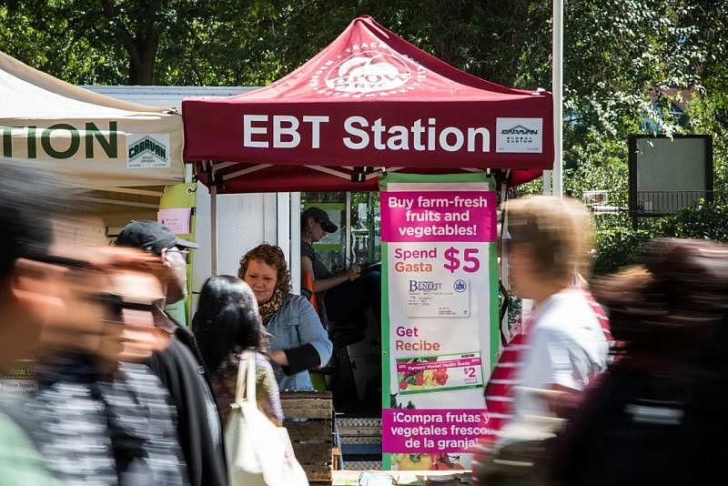 People walk past an EBT station in the GrowNYC Greenmarket in Union Square in New York City.Andrew Burton / Getty Images file