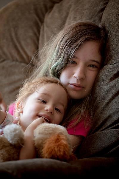 Loryann Pisani de 16 años, sostiene a su hermana, Bethany Cortes, de 2, mientras los adultos trasladan sus pertenencias para mudarse a un nuevo lugar en West Hartford. “Un poco nerviosa”, dijo Loryann. “Es todo nuevo”. YEHYUN KIM / CTMIRROR.ORG