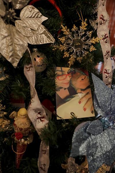 Izquierda: En su dormitorio se muestra un osito de peluche que su hijo le regaló este año. Derecha: Una foto de Carmen Díaz y su novio está en su árbol de Navidad junto con otras fotos familiares. Carmen ama la época navideña y suele decorar toda su casa. "Pero este año, ¿qué voy a hacer con todo esto?" ella dijo. Su familia tiene que mudarse de la casa a fines de febrero.