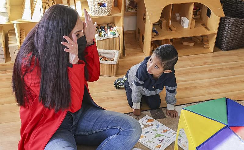 Adriel, 3, looks at a book about dinosaurs with Miren Algorri on Thursday, Nov. 17, 2022.(Eduardo Contreras / The San Diego Union-Tribune)