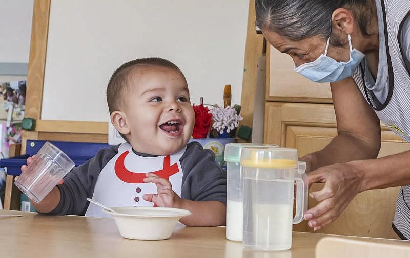 One-year-old Ares shares a laugh with assistant teacher Lucy Arevalo at Miren Algorri’s family child care.(Eduardo Contreras / The San Diego Union-Tribune)