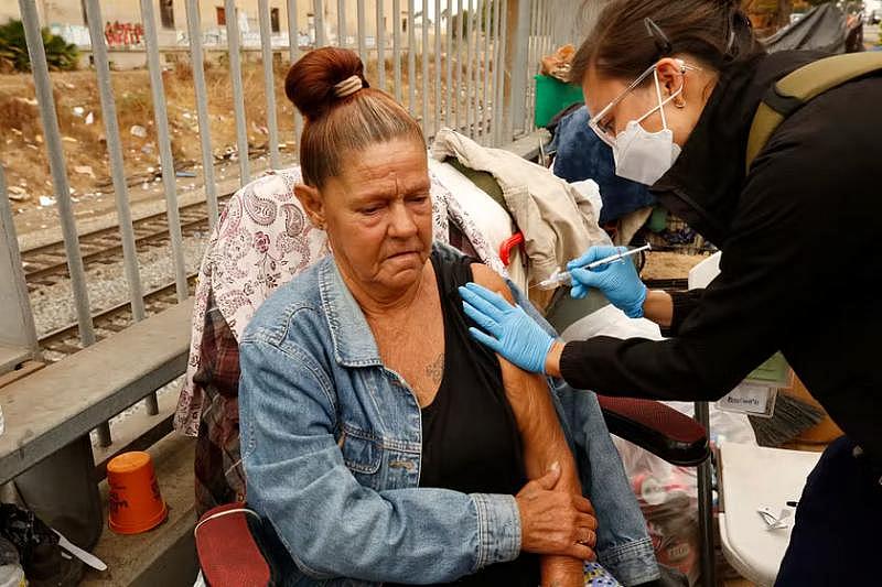 LA County Health Services registered nurse Darian Sumbingco administers the COVID vaccine to Denise Lerma, who was living unhoused near Lincoln Park in Los Angeles, on Thursday, Oct. 7, 2021. Credit: Al Seib/Los Angeles Times/Getty Images.