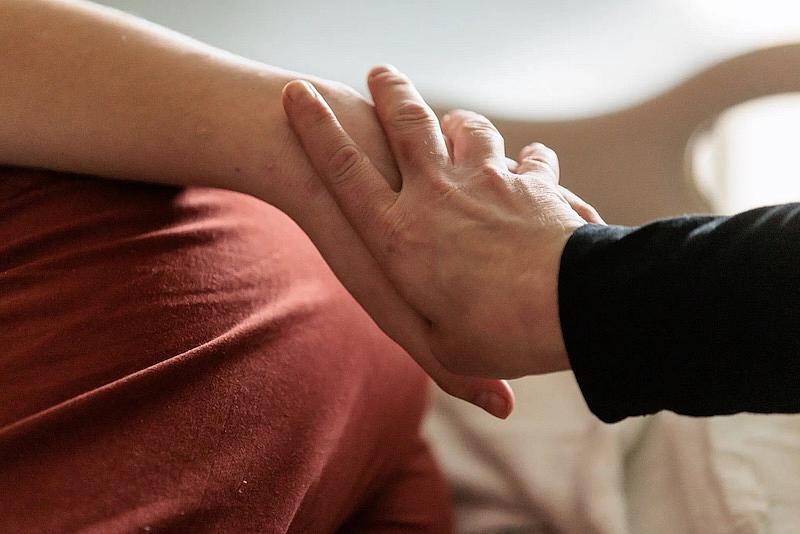 Greta Johnson holds hands with her son Jack at Mary Bridge Children’s Hospital. She visits him every day and worries that he blames her for his situation. (Erika Schultz / The Seattle Times)