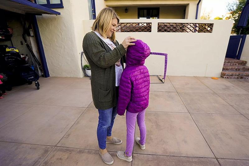 Amanda Buzzell adjusts her daughter’s hair before heading out on a bike ride.(Nelvin C. Cepeda / The San Diego Union-Tribune)