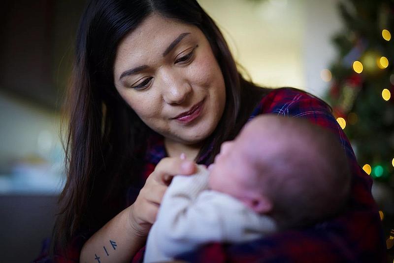 Zaira Reynoso holds her newborn son Ander. Her family makes too much to qualify for state help paying for child care but too little to afford care without help.(Nelvin C. Cepeda / The San Diego Union-Tribune)