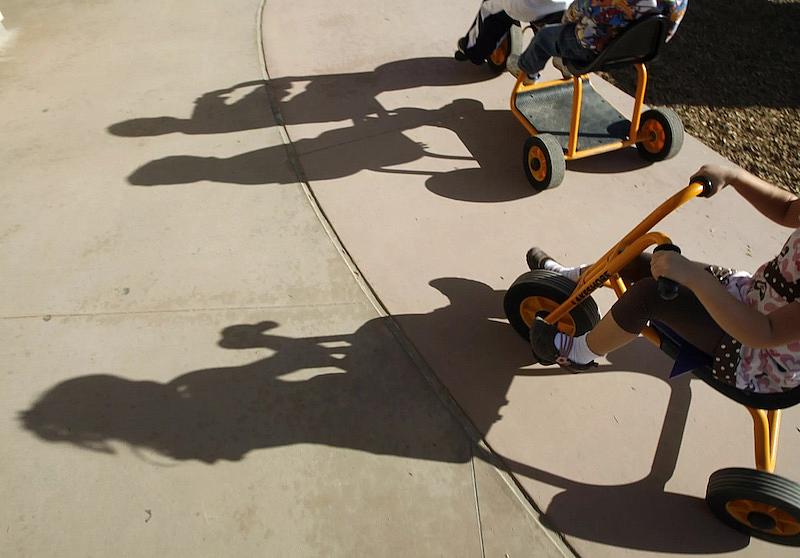 Los niños del Centro para Niños y Familias montan en triciclo en Cal State San Marcos. Después de dos años en los que el estado les ha eximido de pagar las cuotas de las guarderías subvencionadas, muchas familias están a punto de tener que volver a pagarlas.