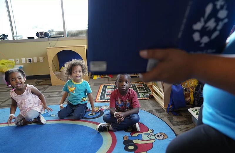 Una profesora de preescolar lee un libro de cuentos a los niños de preescolar de la Aldea de San Vicente de Paúl, en el centro de San Diego. La atención infantil abarca desde la educación temprana, como la que reciben estos niños, hasta la guardería extraescolar.(Nelvin C. Cepeda / The San Diego Union-Tribune)