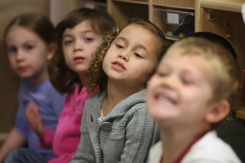 Niños de preescolar escuchan a su maestra en el Centro para Niños y Familias de la CSUSM en San Marcos. En California hay varios programas de guardería subvencionados para los niños de 4 años que cumplan los requisitos, y el nuevo programa de guardería de transición del estado atenderá a un mayor número de ellos en los próximos años.(Hayne Palmour / The San Diego Union-Tribune)