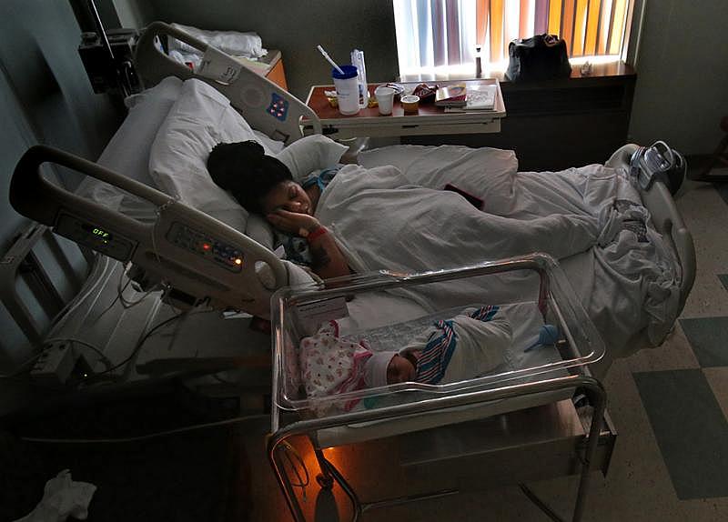 Keonshay Clark, 22, gets some rest alongside her newborn daughter DaKodah in November at Barnes-Jewish Hospital. Clark was screened for maternal depression because her housing situation was in flux. Social workers at the hospital referred Clark to Nurses for Newborns.