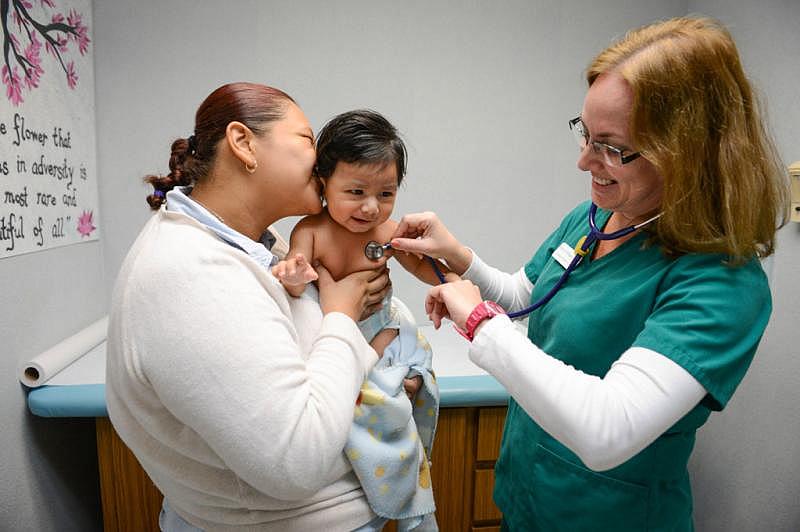 Damarys Velazquez examines Ana Dely Medina’s son, Andres Lorenzo Cruz Medina, at Sarasota Children’s Clinic. STAFF PHOTO / RACHEL S. O’HARA