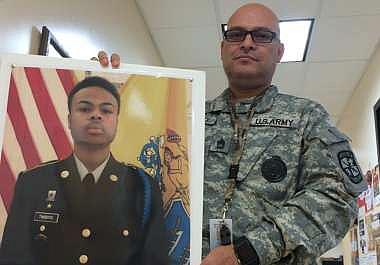 Sgt. 1st Class John Trevino, an Army instructor for the Junior Reserve Officers' Training Corps at Burlington City High School, holds a photo of Antwan Timbers Jr. The sophomore, a JROTC cadet, was fatally struck by a driver who ran off Route 130 last year.