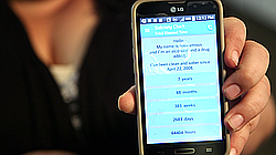 Susan Ireland displays a sobriety clock on her smart phone on Aug. 27, 2015.