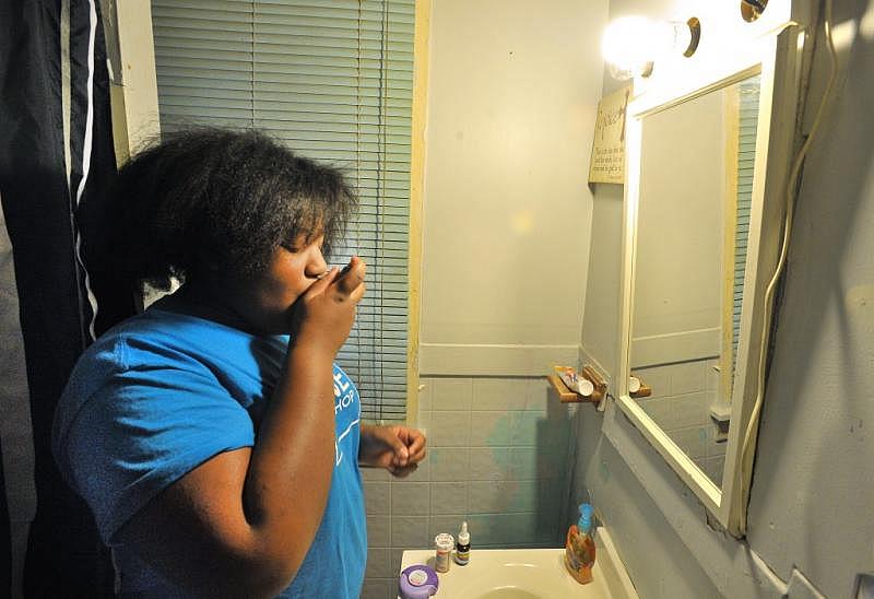 Cameron Carter, 12, takes eight medications every morning to deal with her asthma. Studies show that childhood traumas such as household substance abuse, violence and poverty can trigger asthma. Image by Daniel Mears/The Detroit News