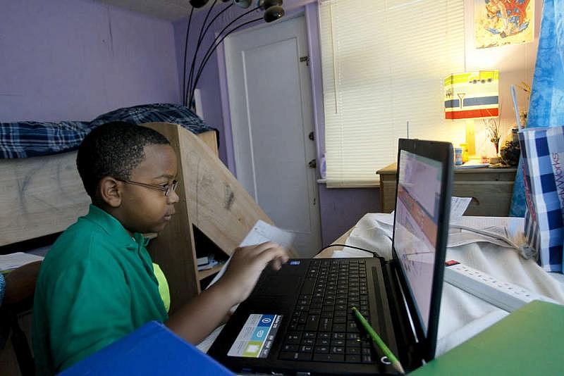 Kailel Rohlsen-Jackson does homework in his bedroom.