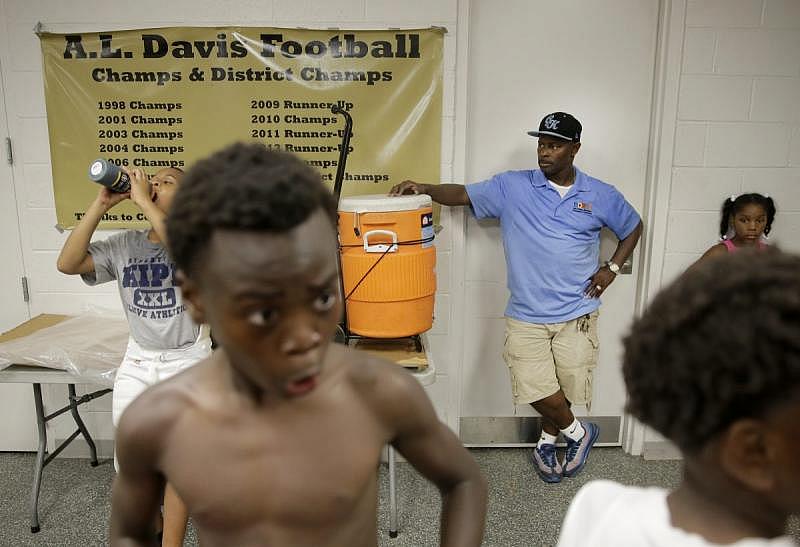 Jerome Temple looks on as players of the A.L. Davis Park Panthers gather in the field house after practice.