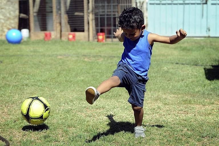 Viririana Covarrubias’ son, 2-year-old Sebastian, kicks a soccer ball at their Fresno home in May. 