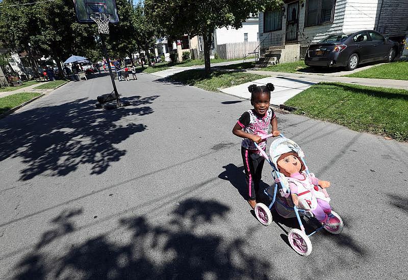 Kaymere Morgan, 3, pushes her doll in its stroller down Humason Avenue, where gunfire struck 11-year-old Juan Rodriguez.