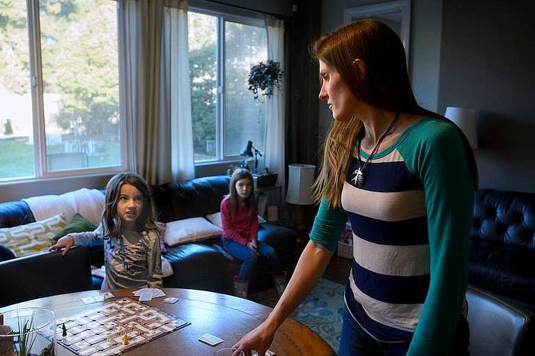 Alison Yeates 7, left, her sister Riley Yeates 9, and their mother Kirsten Yeates play a game at their West Sacramento home on Saturday, January 6, 2018. Less that 21 percent of California parents report that doctors screened children to assess development issues such as autism and determine therapy needs that could avoid years of confusion and frustration. Randall Benton