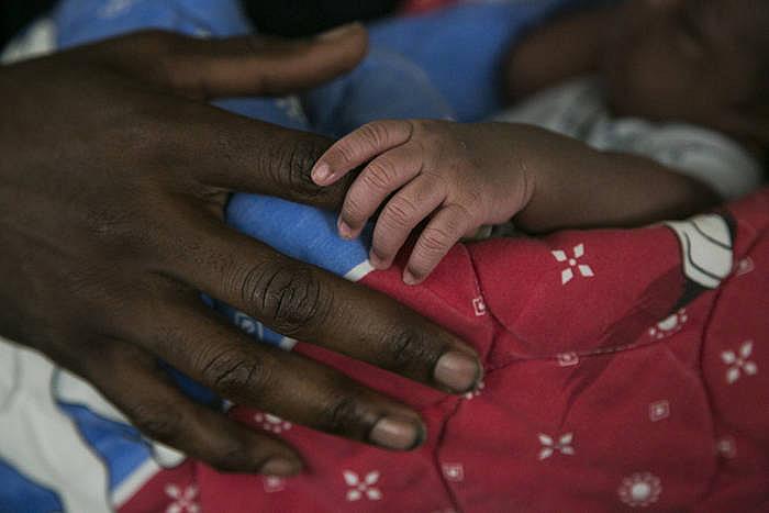 Amound holds onto his father’s finger.