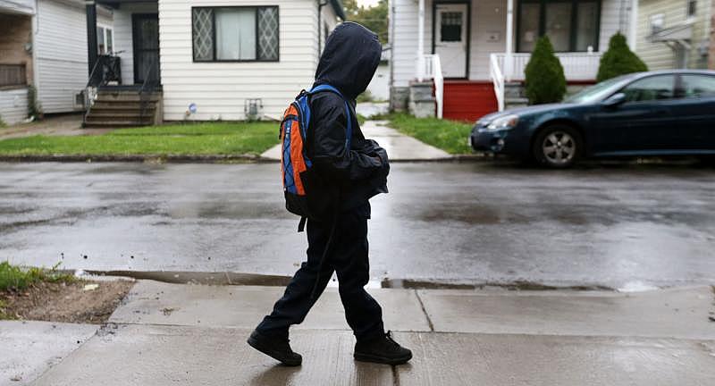Jayden Lawson now lives with his grandmother Cheryl Ruttlen-Brown and step-grandfather Dennis Brown. Jayden, shown here walking to the bus stop, rarely looks forward to going to school. 