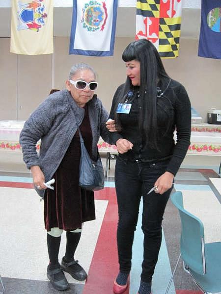 Rocio Vallejos-Hoyt, Services Manager at the Braille Institute, leads Rosenda Guzman around the cafeteria of the agency that offers services to the blind. (Francisco Castro)