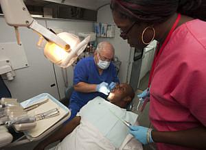Dentist and State Sen. Alan Hays, left, prepares to remove a tooth from patient Sean Washington on the Florida Baptist Convention’s Mobile Dental Unit at the Central Florida Hampton Center car lot Wednesday morning, June 27, 2012 as dental assistant Allison Whipper, right, watches. (Doug Engle/Star-Banner) Dentist and State Sen. Alan Hays, left, prepares to remove a tooth from patient Sean Washington on the Florida Baptist Convention’s Mobile Dental Unit at the Central Florida Hampton Center car lot Wednesday morning, June 27, 2012 as dental assistant Allison Whipper, right, watches. (Doug Engle/Star-Banner)
