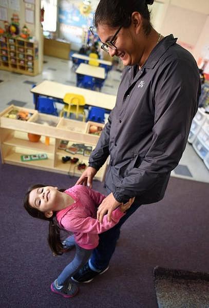 Three-year-old Emma plays with her father, 18-year-old Kevin Aguilar, at Sequoia Head Start before he heads to class at the School of Unlimited Learning. John Walker