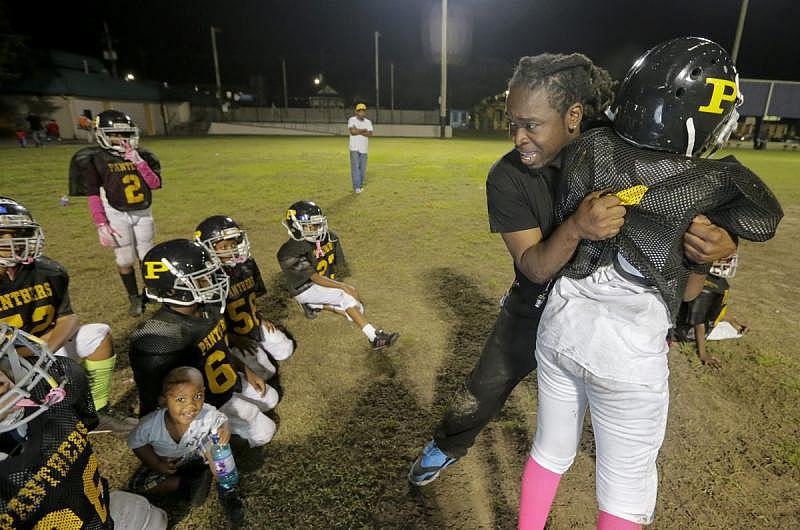 Assistant coach Claude Dixon gives instructions to members of the A.L. Davis Park Panthers during practice.