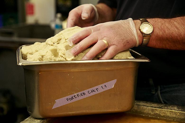 Dunn prepares to load corn-masa dough fortified with folic acid into the hopper of a tortilla maker. (Erika Schultz / The Seattle Times) Dunn prepares to load corn-masa dough fortified with folic acid into the hopper of a tortilla maker. (Erika Schultz / The Seattle Times)