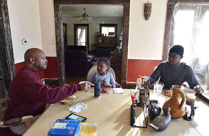 Vickerson shares breakfast with his grandchildren Jakari, 15, and Amor, 6, one Saturday in February. The kids are two of the 128,000 children in Georgia who are being cared for by family members other than their parents. The large majority are grandparents. HYOSUB SHIN / HSHIN@AJC.COM