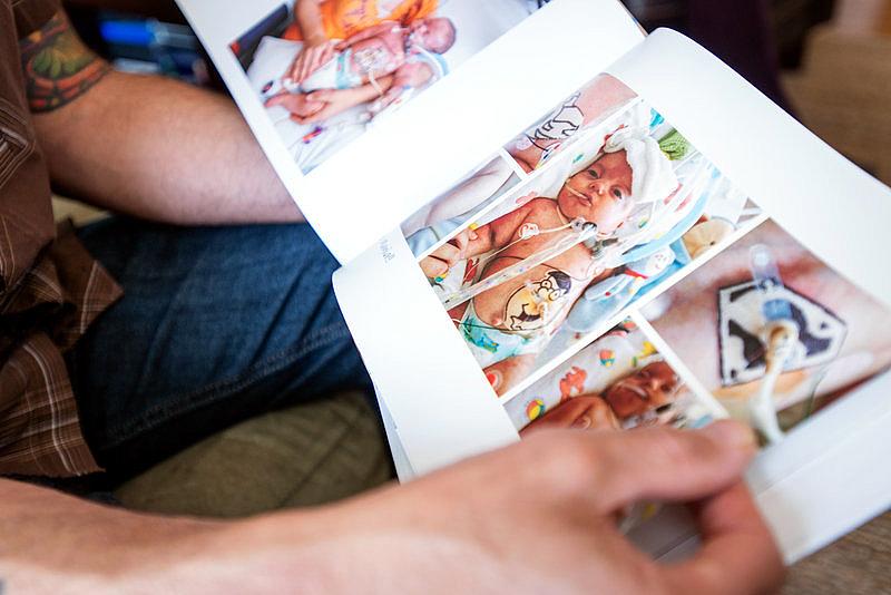 Omar looks through Kai's photo book. The charges for the infant's six months of care in the neonatal intensive care unit totaled about $11 million, according to the family, though their insurer very likely negotiated a lower rate. Heidi de Marco/KHN Omar looks through Kai's photo book. The charges for the infant's six months of care in the neonatal intensive care unit totaled about $11 million, according to the family, though their insurer very likely negotiated a lower rate. Heidi de Marco/KHN