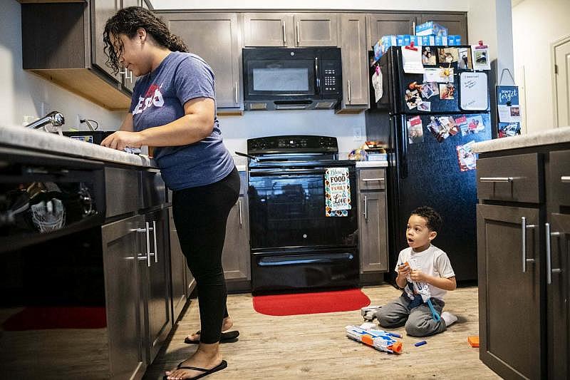 Destiny Clark, left, 22, prepares to cook breakfast for her son Tevin Webster, 4, Friday, Jan. 25, 2019, at the newly built Family Scholar House campus in Louisville, Ky.