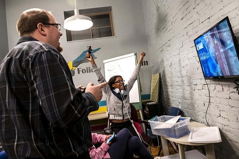Danielle Washington, right, attends Volunteers of America’s Teens with a Purpose program, which gives teen living in the transitional housing and emergency family shelter, a space to interact with each other and volunteers including Greg Hummel, left.