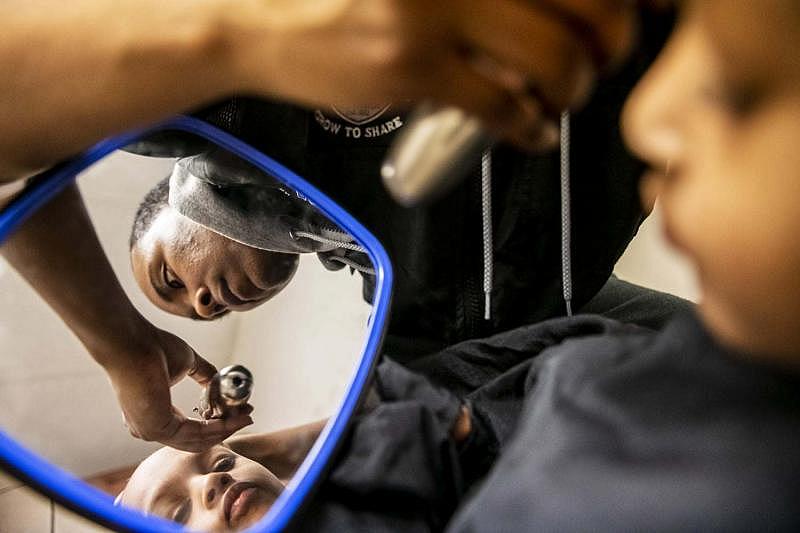 Amauri Ray, left, 3, gets a haircut from his godfather Mark Pence, Wednesday, Feb. 13, 2019, in Louisville, Ky.