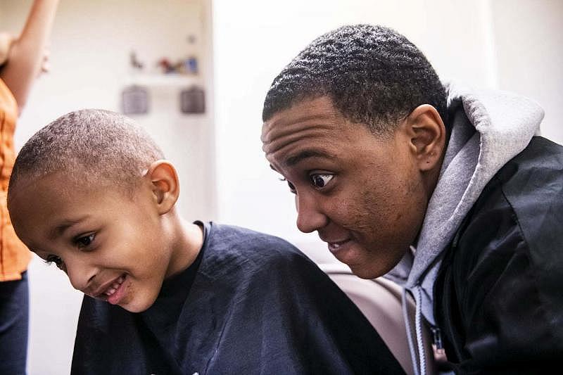 Amauri Ray, 3, left, and his godfather Mark Pence smile as they check out Amauri’s new haircut in a mirror, Wednesday, Feb. 13, 2019, in Louisville, Ky.