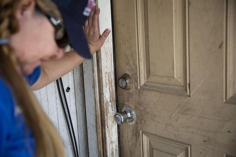 During a home visit, Montalvo waits for someone to answer their door. [Photo by Angela Piazza]