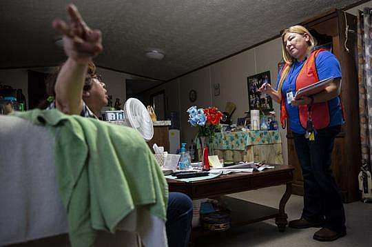 Peilar Muro, 66, tells Montalvo, right, her trailer home needs a wheelchair ramp and skirting. [Photo by Angela Piazza]